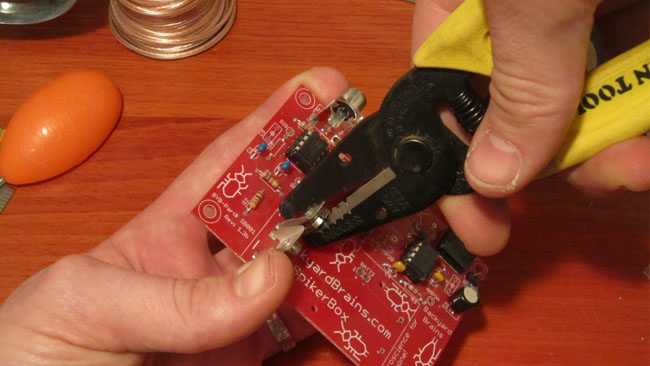 Using pliers, lightly rock back and forth the battery connectors on the bottom board to snap them off.
