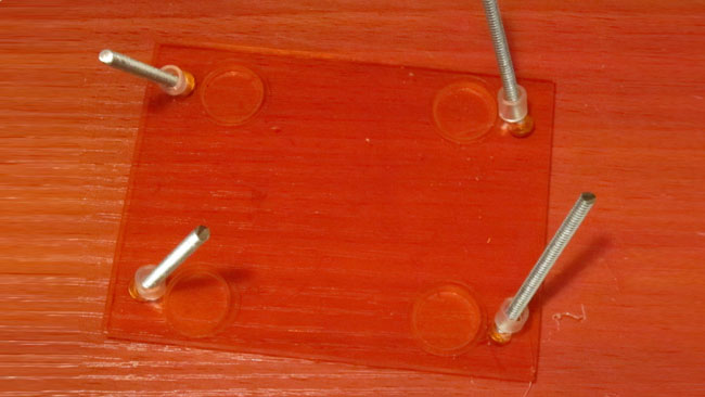 Insert the 2 inch screws through your bottom acrylic (bottom of SpikerBox), and place the small spacers on the other side of the screws.