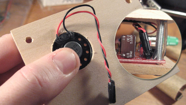 Press the speaker into the enclosure, then attach the female end of the cord to the male end of the PCB.