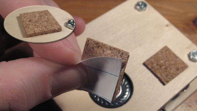 Peel and place the cork stickers to the right of the speaker, close to the RCA jack.  You will need to stack up 2 stickers so that the cork is thick enough for the needles to stay in place.